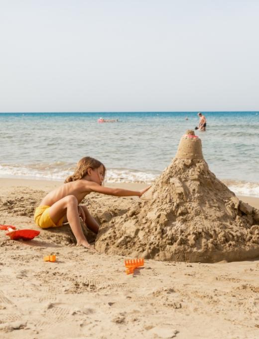 Tramonto romantico sulla spiaggia con una coppia e una barca in mare.