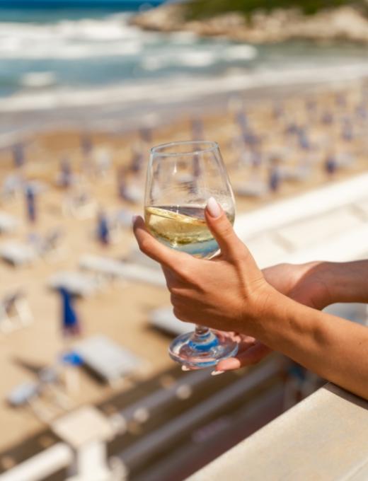 Due persone corrono verso il mare su una spiaggia al tramonto.